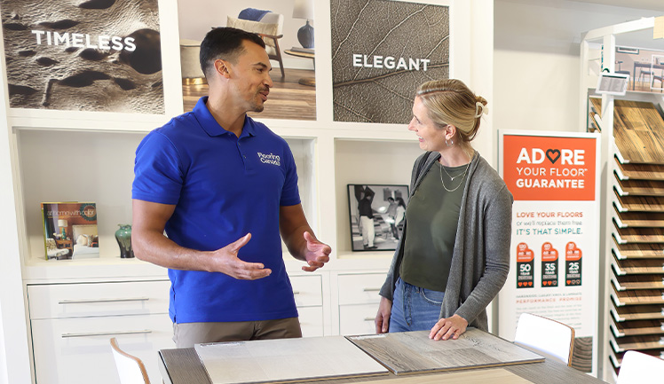 woman looking at flooring samples in showroom with flooring expert