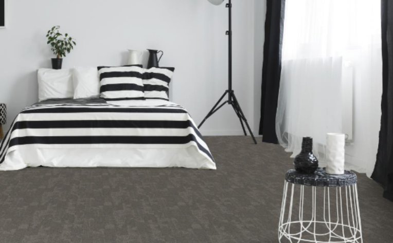 A modern bedroom utilizing 2020 themed colors to include stormy blue walls, grey planters, and a natural wood headboard.