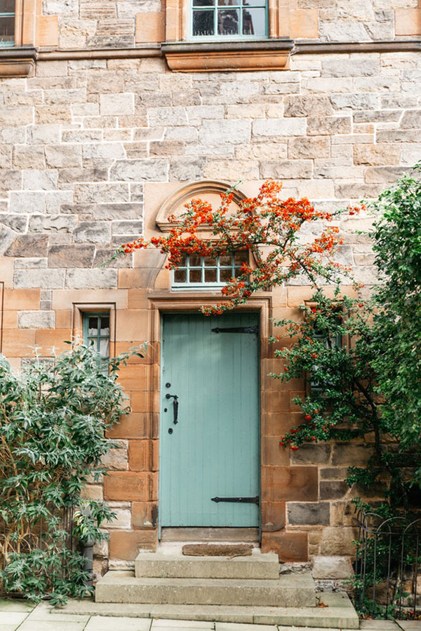 Light blue wooden front door on a stone house